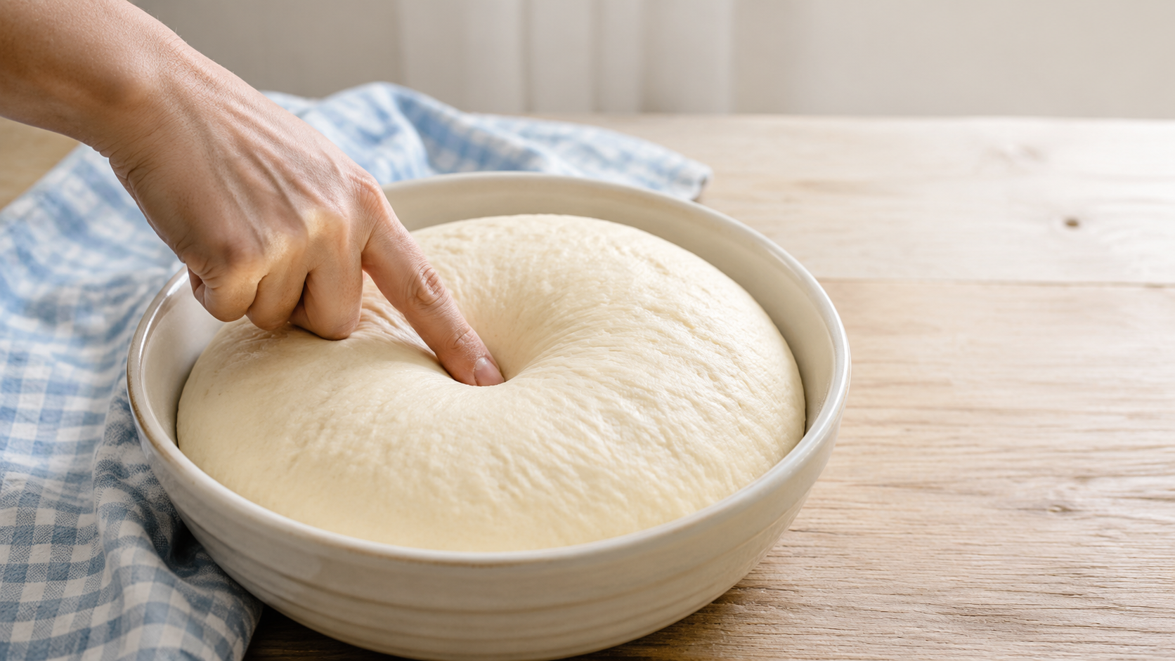 Floured finger testing whether risen bread dough is ready using the poke test